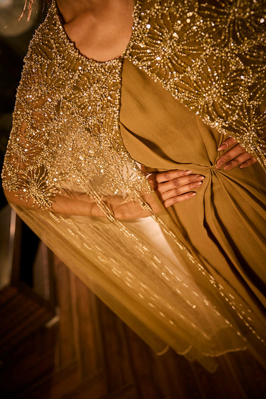 Olive green dress paired with an embellished sheer cape