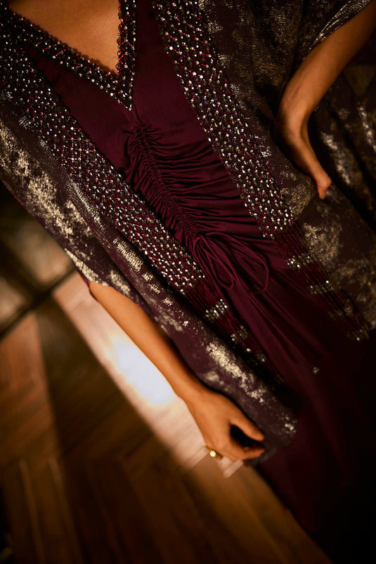 Ruched knot dress with a gold crushed foil cape